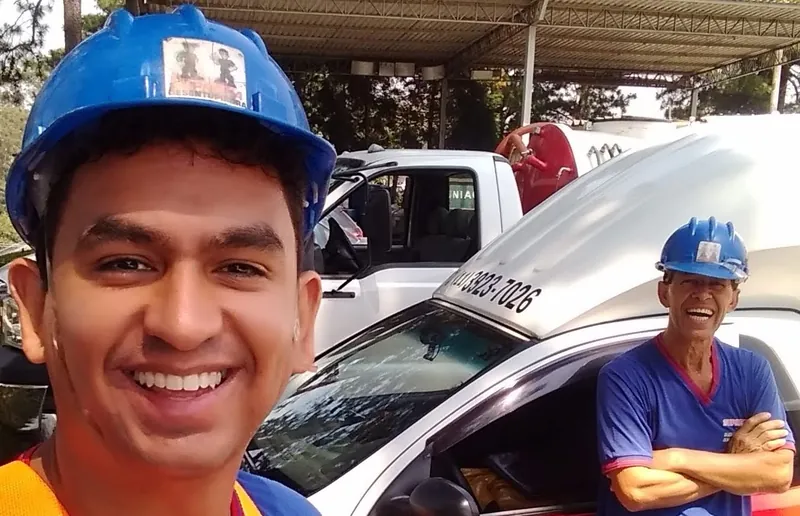 Técnicos da equipe Suprema Desentupidora de capacete ao lado da viatura; atendimento em Centro, Belo Horizonte